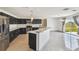 Modern kitchen featuring dark cabinetry, stainless steel appliances, and bright countertops at 1038 Sabine Pl, Kissimmee, FL 34759