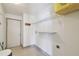 Compact laundry room with shelving for storage and tile flooring at 1038 Sabine Pl, Kissimmee, FL 34759