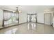 Bright, empty living room with stylish light fixture and large windows at 1038 Sabine Pl, Kissimmee, FL 34759