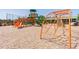 View of playground with orange, green, and climbing equipment on wood chip ground cover at 1038 Sabine Pl, Kissimmee, FL 34759