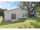 Home featuring spacious, grassy backyard with mature tree, concrete patio, and partial privacy fence at 108 Pearlwood St, Orlando, FL 32811