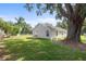 Home with spacious, grassy backyard with a large tree and privacy fence at 108 Pearlwood St, Orlando, FL 32811
