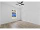 Bright bedroom features sleek ceiling fan, wood-look floors, and a window with a view at 108 Pearlwood St, Orlando, FL 32811