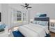 Bright bedroom with large windows, ceiling fan, tufted headboard, and blue accents at 108 Pearlwood St, Orlando, FL 32811