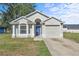 Charming single-story home with a well-manicured lawn, featuring a light gray facade and a blue front door at 108 Pearlwood St, Orlando, FL 32811