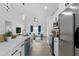 Bright, open kitchen with white cabinets, stainless steel appliances, island with seating, and modern lighting at 108 Pearlwood St, Orlando, FL 32811