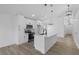 Open-concept kitchen with white cabinets, center island, and modern pendant lighting above a breakfast bar at 108 Pearlwood St, Orlando, FL 32811