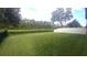 Lush backyard with sprawling green lawn and tranquil water view provides a serene outdoor space at 12867 Woodmere Close Dr, Windermere, FL 34786