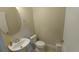 Cozy half bathroom featuring a pedestal sink with a round mirror, standard toilet, and white trim at 12867 Woodmere Close Dr, Windermere, FL 34786