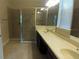Well lit bathroom featuring a double sink vanity and a glass enclosed shower with tile surround at 12867 Woodmere Close Dr, Windermere, FL 34786