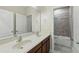 Bathroom featuring a double vanity and a shower/tub combination with glass doors at 12867 Woodmere Close Dr, Windermere, FL 34786