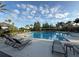 Resort-style community pool with lounge seating, palm trees, and shaded areas at 12867 Woodmere Close Dr, Windermere, FL 34786