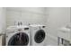 Bright laundry room featuring a washer and dryer set with utility sink and storage shelf at 12867 Woodmere Close Dr, Windermere, FL 34786
