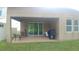 Covered outdoor patio with seating area and a grill overlooking the backyard at 12867 Woodmere Close Dr, Windermere, FL 34786