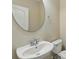 Compact powder room featuring a round mirror, pedestal sink, and a standard toilet at 12867 Woodmere Close Dr, Windermere, FL 34786
