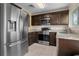Updated kitchen featuring stainless steel appliances, granite countertops, and dark wood cabinetry at 13427 Fairway Glen Dr # 103, Orlando, FL 32824