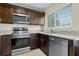 This kitchen features stainless steel appliances, granite countertops, and dark wood cabinetry at 13427 Fairway Glen Dr # 103, Orlando, FL 32824