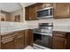 Updated kitchen featuring stainless steel appliances, granite countertops, and dark wood cabinetry at 13427 Fairway Glen Dr # 103, Orlando, FL 32824