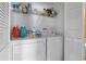 Bright laundry area with washer, dryer, storage shelf, and cleaning supplies at 13427 Fairway Glen Dr # 103, Orlando, FL 32824