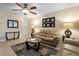 Well-lit living room with tile floors, a ceiling fan, couches, and decorative lamps at 13427 Fairway Glen Dr # 103, Orlando, FL 32824