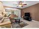 Cozy living room showcasing tile floors, neutral paint, ceiling fan, and comfortable seating at 13427 Fairway Glen Dr # 103, Orlando, FL 32824