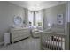 Bedroom with crib, changing table, glider, and decor at 15079 Guava Bay Dr, Winter Garden, FL 34787