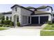 Attractive home exterior with a stone facade, brick driveway, and two-car garage at 15079 Guava Bay Dr, Winter Garden, FL 34787