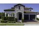 Beautiful home exterior featuring a stone facade, arched entry, and a two-car garage with a brick driveway at 15079 Guava Bay Dr, Winter Garden, FL 34787