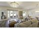 Bright living room showcasing a plush sofa, glass doors to the backyard, and a stunning chandelier at 15079 Guava Bay Dr, Winter Garden, FL 34787