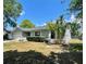Well-kept gray home featuring a manicured lawn, lush greenery, and healthy palm tree adding curb appeal at 1561 Cypress Woods Cir, St Cloud, FL 34772