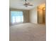 Bright, open living room with carpet flooring, sheer curtains and a view to the home's inviting entry at 1561 Cypress Woods Cir, St Cloud, FL 34772