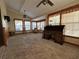 Cozy living room with a vaulted ceiling, carpeted floors, large windows, and vintage desk at 1835 Harbor Blvd, Kissimmee, FL 34744