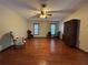 Spacious living room area with a ceiling fan, wood floors, and two windows at 1835 Harbor Blvd, Kissimmee, FL 34744