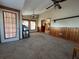 Carpeted living room with wood paneling, two ceiling fans, and access to other rooms at 1835 Harbor Blvd, Kissimmee, FL 34744