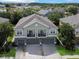 An aerial view of this two-story home shows a three-car garage and balcony, highlighting curb appeal and outdoor living at 1933 Estancia Cir, Kissimmee, FL 34741