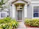 Charming front door entrance with gray paint, sidelights, and a welcoming pathway at 1933 Estancia Cir, Kissimmee, FL 34741