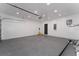 An empty garage with white brick walls, gray epoxy floors, and storage units at 2040 Patriot Way, St Cloud, FL 34769