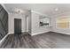 View of the expansive living room with elegant hardwood flooring and a stylish accent wall at 2040 Patriot Way, St Cloud, FL 34769