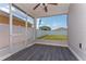 The patio is screened in with gray wood flooring and a fan overhead at 2040 Patriot Way, St Cloud, FL 34769