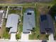 Aerial view of a home with a screened-in pool and solar panels on the roof at 2206 Hunters Greene Dr, Lakeland, FL 33810