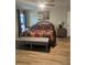 Bedroom featuring a decorative comforter, wood floors, and accent wall art at 2206 Hunters Greene Dr, Lakeland, FL 33810