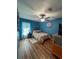 Cozy bedroom with wood floors, blue walls, and a ceiling fan with light at 2206 Hunters Greene Dr, Lakeland, FL 33810