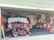 Open garage with a red truck, lawn mower and assorted tools at 2206 Hunters Greene Dr, Lakeland, FL 33810