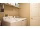 Functional laundry room with washer, dryer, and storage shelves for supplies at 2206 Hunters Greene Dr, Lakeland, FL 33810