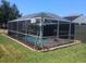 A screened-in pool features inviting cool water, pink flamingos and an ornamental windmill at 2206 Hunters Greene Dr, Lakeland, FL 33810