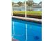 Bright blue swimming pool surrounded by a screened-in lanai and lush landscaping at 2206 Hunters Greene Dr, Lakeland, FL 33810