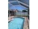 Sparkling blue pool with a screened-in enclosure and privacy fence at 2206 Hunters Greene Dr, Lakeland, FL 33810