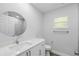 Modern bathroom featuring a large round mirror, quartz countertops, and white shaker cabinets at 225 Starling Ct, Kissimmee, FL 34759