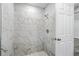 Contemporary shower featuring marble-look tile, a rain shower head, and a white hexagon tile floor at 225 Starling Ct, Kissimmee, FL 34759