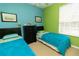 Colorful bedroom with twin beds, bright walls, and natural light at 2301 Butterfly Palm Way # 303, Kissimmee, FL 34747